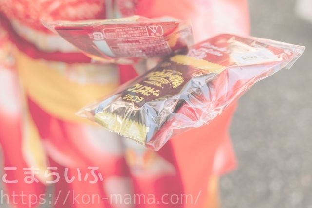 七五三のスタジオ撮影で、緊張した子どもにお菓子を渡してリラックスさせる様子の写真。