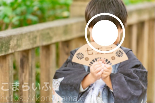 七五三で袴を着た男の子が「七五三」と書かれた扇子を持っている様子。