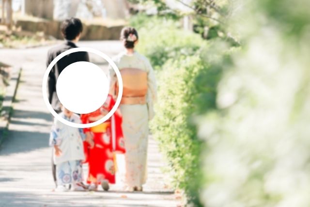七五三の日、着物姿の家族が神社の参道を歩く後ろ姿。