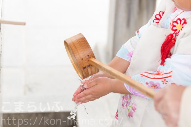 七五三のお参り前に、手水舎で手を清める子どもの姿。