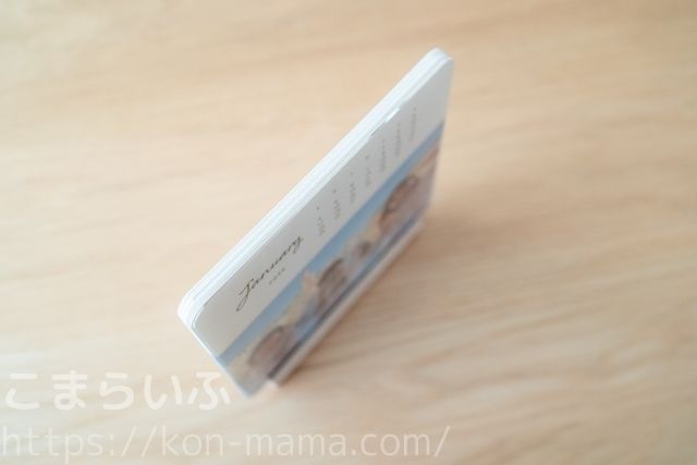しまうまカレンダーを木製スタンドに立てた状態を上から撮影した写真。カレンダーの厚みと安定感がわかる。
