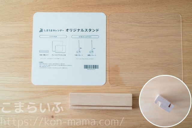 しまうまカレンダー専用の木製スタンドと透明アクリルプレート、説明カードが並べられた写真。