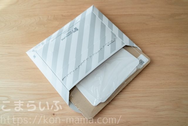 しまうまカレンダーの封筒を開封した直後の写真。内部には透明袋に包まれたカレンダーセットが見えている。