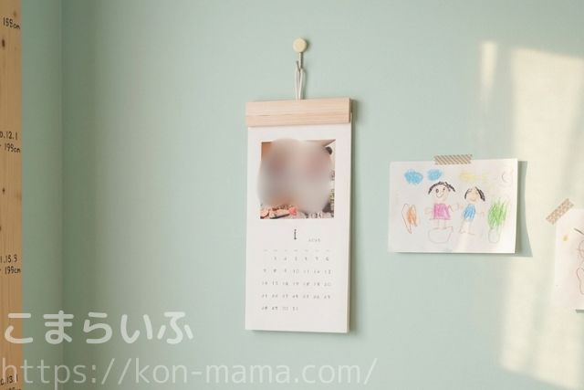 OKURU子どもの手書きカレンダーを壁に飾った様子(子どもの絵と一緒に飾られた生活シーン)