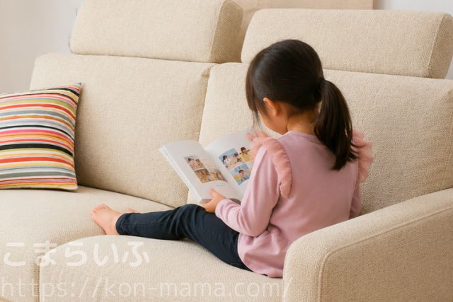 子どもが自分のフォトブックを見返している様子