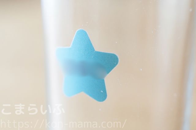 ガラスのコップに貼り付けた青い星形の名前シール